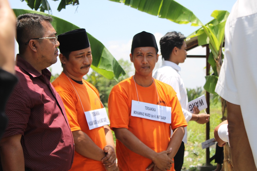 IDENTIFIKASI: Tersangka pertikaian berdarah di Kecamatan Tanjungbumi Hasan Basri dan Wardi didampingi kuasa hukumnya saat reka ulang di Jalan Kinibalu, Bangkalan, Senin (26/2). (VIVIN AGUSTIN HARTONO)