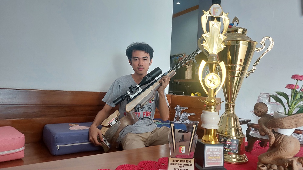 PRESTISIUS: Ahmad Athariq Hidayat menunjukkan salah satu koleksi senapan dan trofi di rumahnya, Kelurahan Gunung Sekar, Kecamatan Sampang, Sabtu (16/3). (JUNAIDI PONDIYANTO/JPRM)