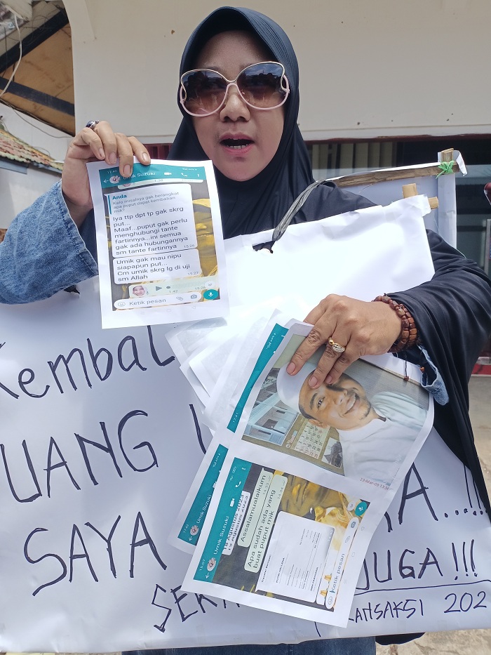 TAGIH UTANG: Putri Helena, warga Surabaya, melakukan aksi tunggal di depan kantor Travel Umrah Annuqa, Jalan Raya Lenteng, Desa Kebonagung, Kecamatan Kota Sumenep, Senin (26/2). (MOH. IQBAL/JPRM)