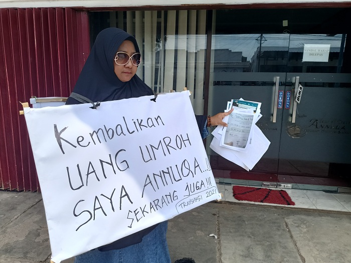 DEMO TUNGGAL: Putri Helena, warga Surabaya, melakukan aksi di depan kantor Travel Umrah Annuqa, Jalan Raya Lenteng, Desa Kebonagung, Kecamatan Kota Sumenep, Senin (26/2). (MOH. IQBAL/JPRM)