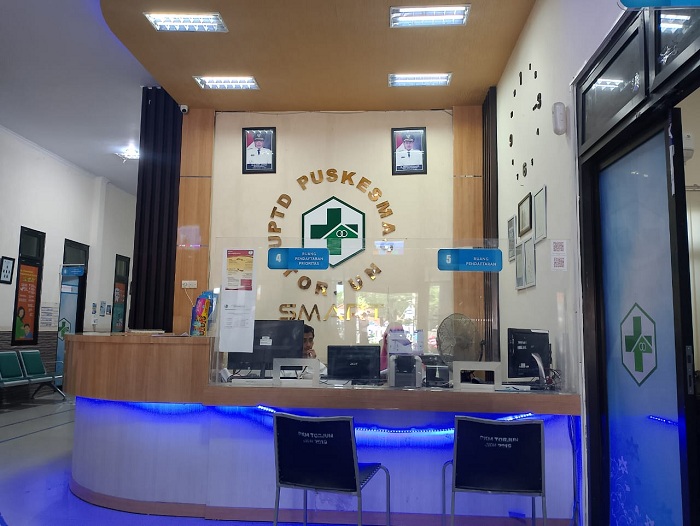 BERTUGAS: Karyawan Puskesmas Torjun, Sampang, sedang berada di ruang resepsionis Selasa (19/3). (UBAIDILLAHIR RA&rsquo;IE/JPRM)