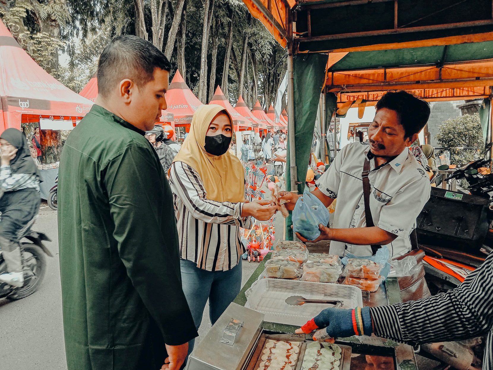 CARI TAKJIL: Warga membeli jajanan kepada pedagang yang berjualan di stan Bazar Takjil Ramadan Senin (18/3). (MOH. JUNAIDI/JPRM)