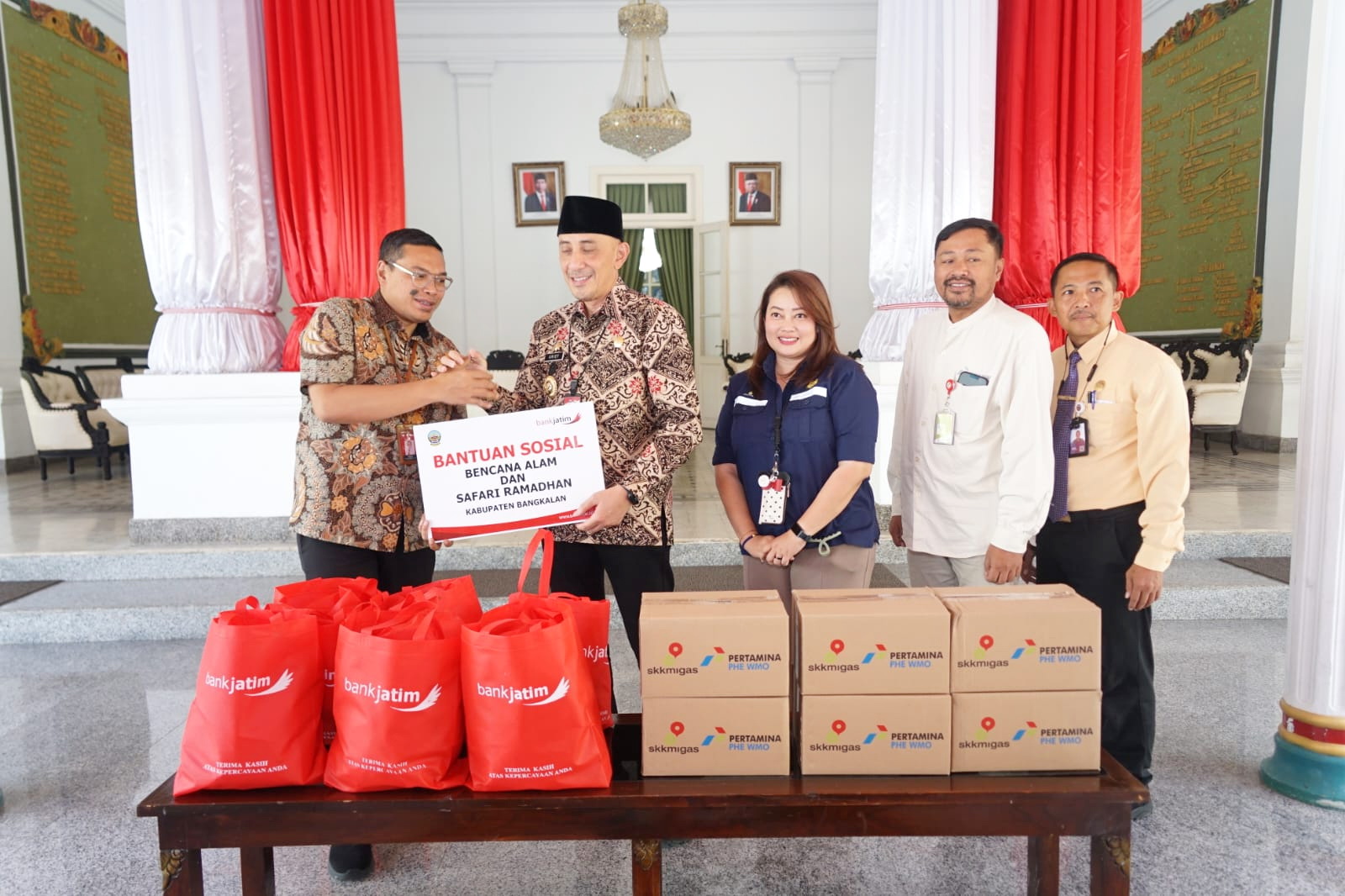 PEDULI: Pemimpin Cabang Bank Jatim Bangkalan Achmad Riyan Fatri (kiri) menyerahkan bantuan secara simbolis kepada Pj Bupati Bangkalan Arief M. Edie di Pendopo Agung, Kamis (21/3). (PROKOPIM BANGKALAN)