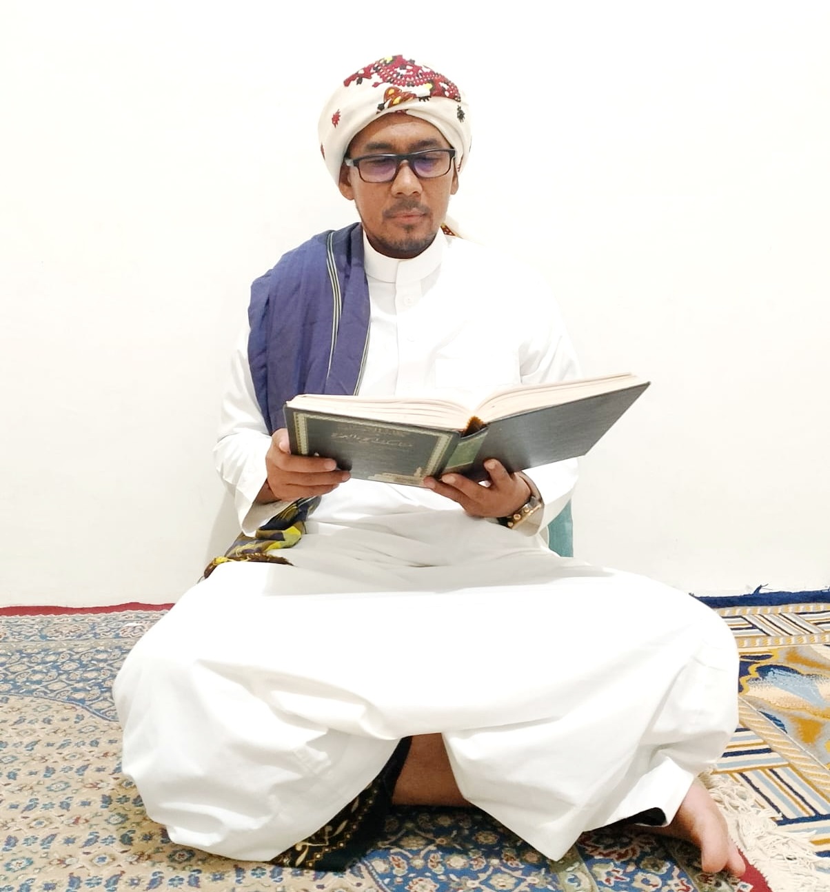 METODE DAKWAH: Dewan Pengasuh Ponpes Kebun Wangi Nagasari, Bluuran, Karang Penang, Sampang Kiai Abd. Wahid Siradj sedang membaca kitab di kediamannya, Minggu (17/3). (UBAIDILAHIR RAIE/JPRM)