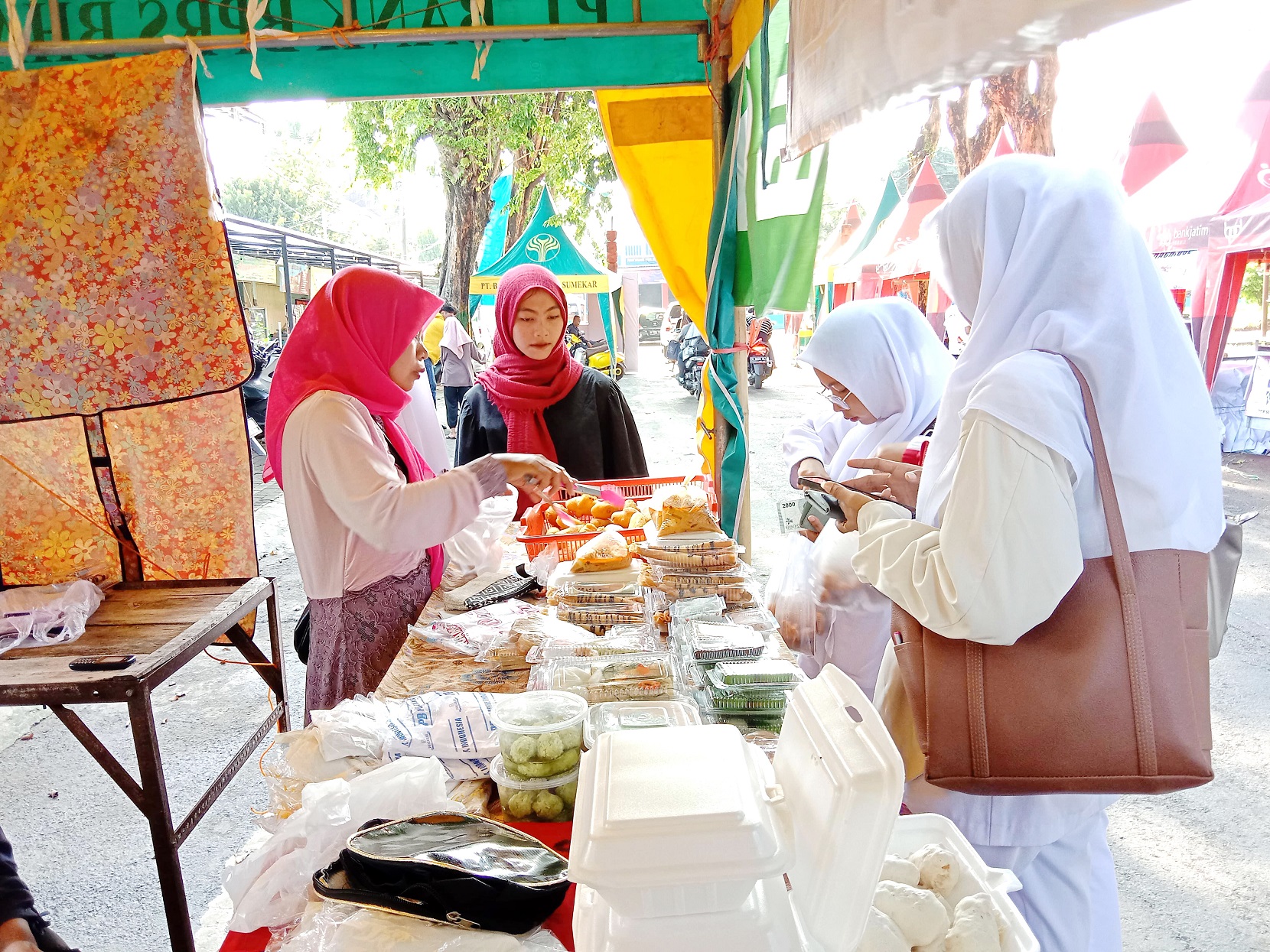RAMAI: Samiyah, penjual Bazar Takjil Ramadan Sumenep, melayani pembeli di stannya Rabu (20/3). (MOH. JUNAIDI/JPRM)