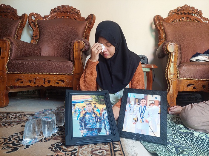 BERDUKA: Nabila Ayu Pratiwi tak kuasa menahan tangis saat memperlihatkan foto almarhum suaminya, Muhammad Munir Agung Suhartono di kediamannya, Kelurahan Pangeranan, Bangkalan, Kamis (21/3).