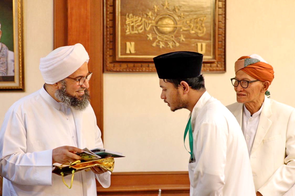 KAROMAH: Lora Muhammad Ismail Al Ascholy (kopiah hitam) memberikan kitab karyanya dan kitab Syaikhona Muhammad Kholil kepada Habib Ali Al-Jufri disaksikan Rais Aam PBNU KH Miftachul Akhyar.