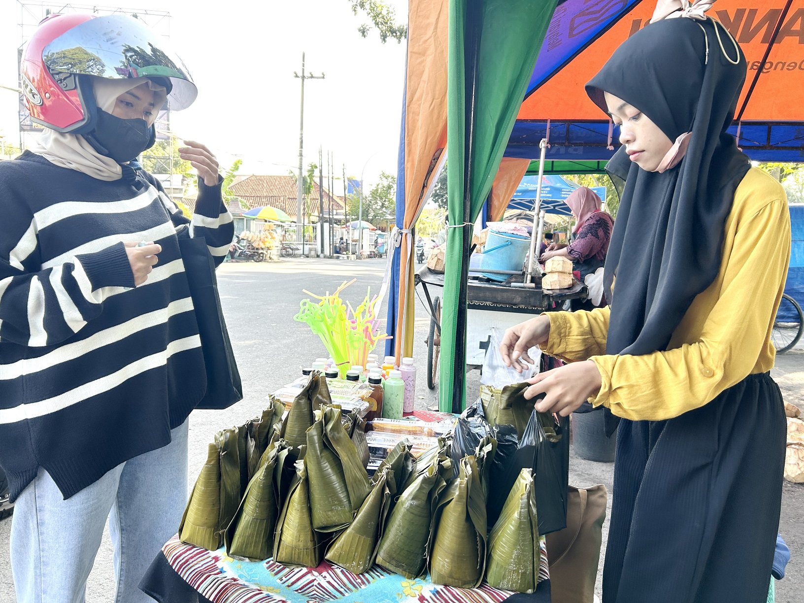 LARIS MANIS: Farihatul Laila melayani pelanggan membeli bongko di Bazar Takjil Ramadan di Jalan Letnan Abdullah, Bangkalan, Rabu (20/3). (VIVIN AGUSTIN HARTONO/JPRM)