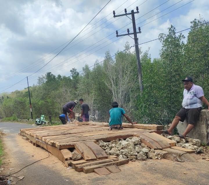 HASIL URUNAN: Sejumlah warga bergotong royong membuat jembatan alternatif dari kayu di Desa Bilis-Bilis, Kecamatan Arjasa, Kamis (16/11/2023). (MATRAHIM Untuk JPRM)