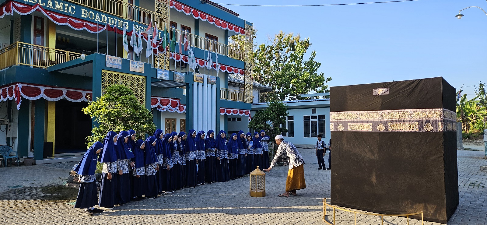 MEMBIMBING: Mohammad Holis memberikan pembelajaran praktik manasik haji dan umrah di halaman IBS PKMKK. (IBS PKMKK UNTUK JPRM)
