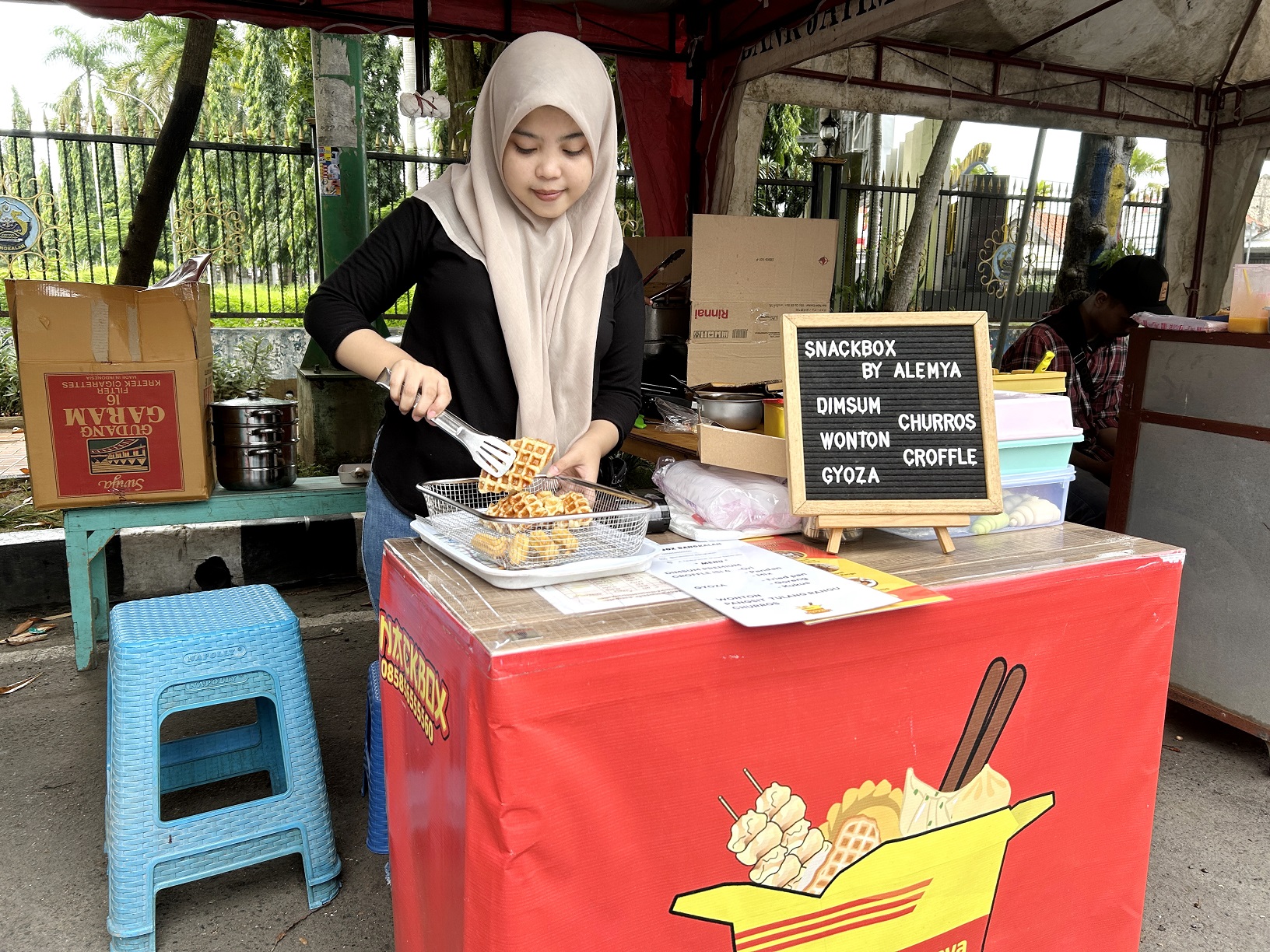 UNIK: Dinda Citra sedang menyuguhkan dagangannya di stan Bazar Takjil Ramadan, Jalan Letnan Abdullah, Senin (25/3). (VIVIN AGUSTIN HARTONO/JPRM)