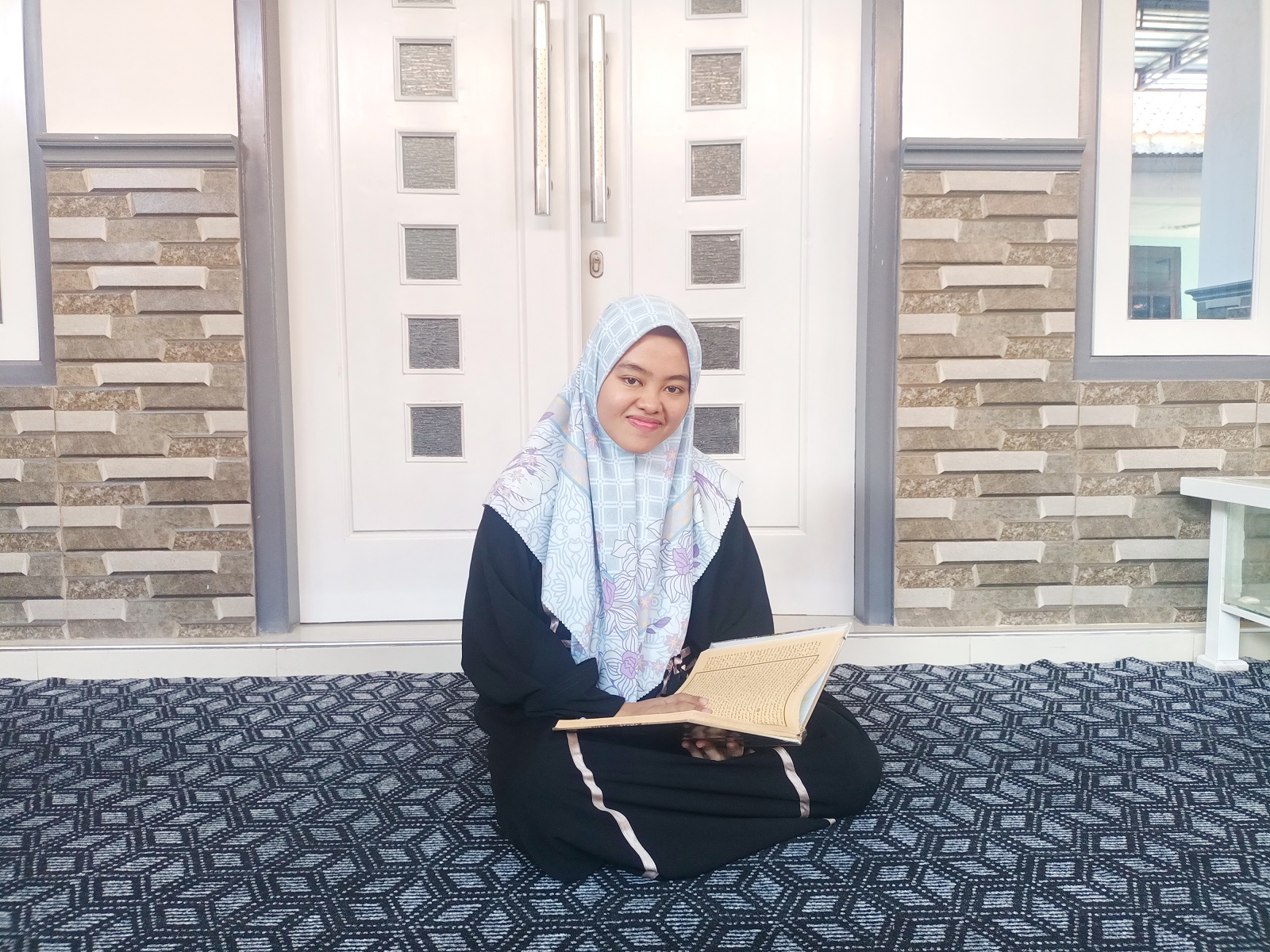 BERPARAS CANTIK: Shofiatul Ummah membuka Kitab Kuning di kediamannya di Desa/Kecamatan Ganding, Sumenep, Sabtu (23/3). (MOH. IQBAL/JPRM)