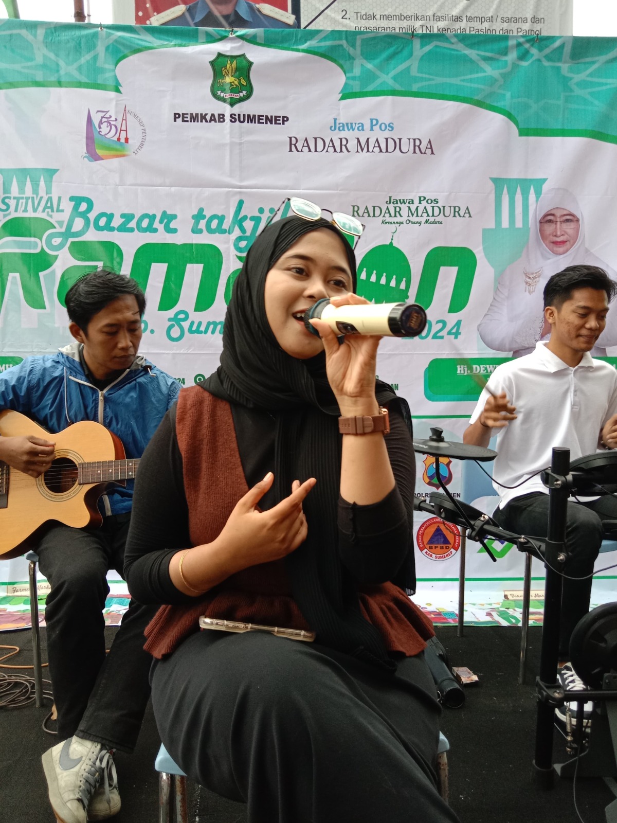 MENGHIBUR: Kirana Rahadian Putri bernyanyi bersama grup musik Musician Project di Bazar Takjil Ramadan JPRM, Jalan Kesatrian, depan Kodim Sumenep, Minggu (17/3). (MOH. IQBAL/JPRM)