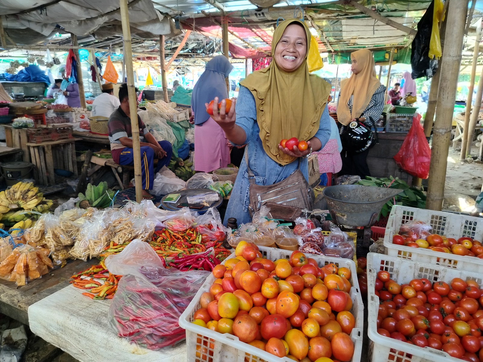 HARGA NAIK: Aisyah, pedagang Pasar Kolpajung, Pamekasan, menjajakan tomat Selasa (26/3). (LAILIYATUN NURIYAH/JPRM)