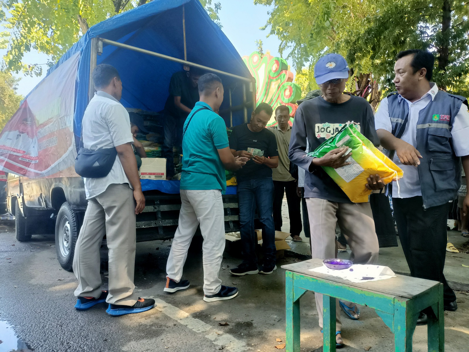 KEBUTUHAN POKOK: Warga membeli beras saat pemkab menggelar pasar murah di Taman Bunga Pottre Koneng, Sumenep, Rabu (27/3). (MOH. IQBAL/JPRM)