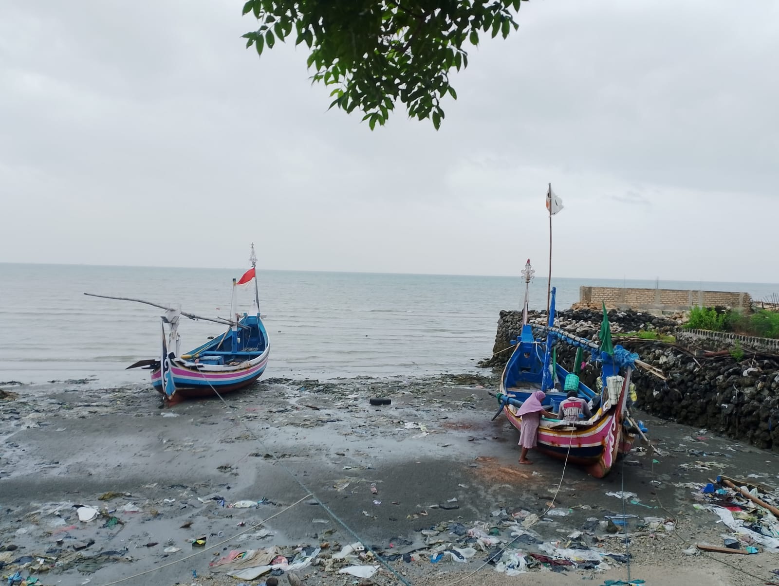 TIDAK MELAUT: Nelayan memperbaiki perahunya di Kecamatan Camplong, Sampang, Jumat (29/3). (UBAIDILLLAHIR RA&rsquo;IE/JPRM)  &nbsp;