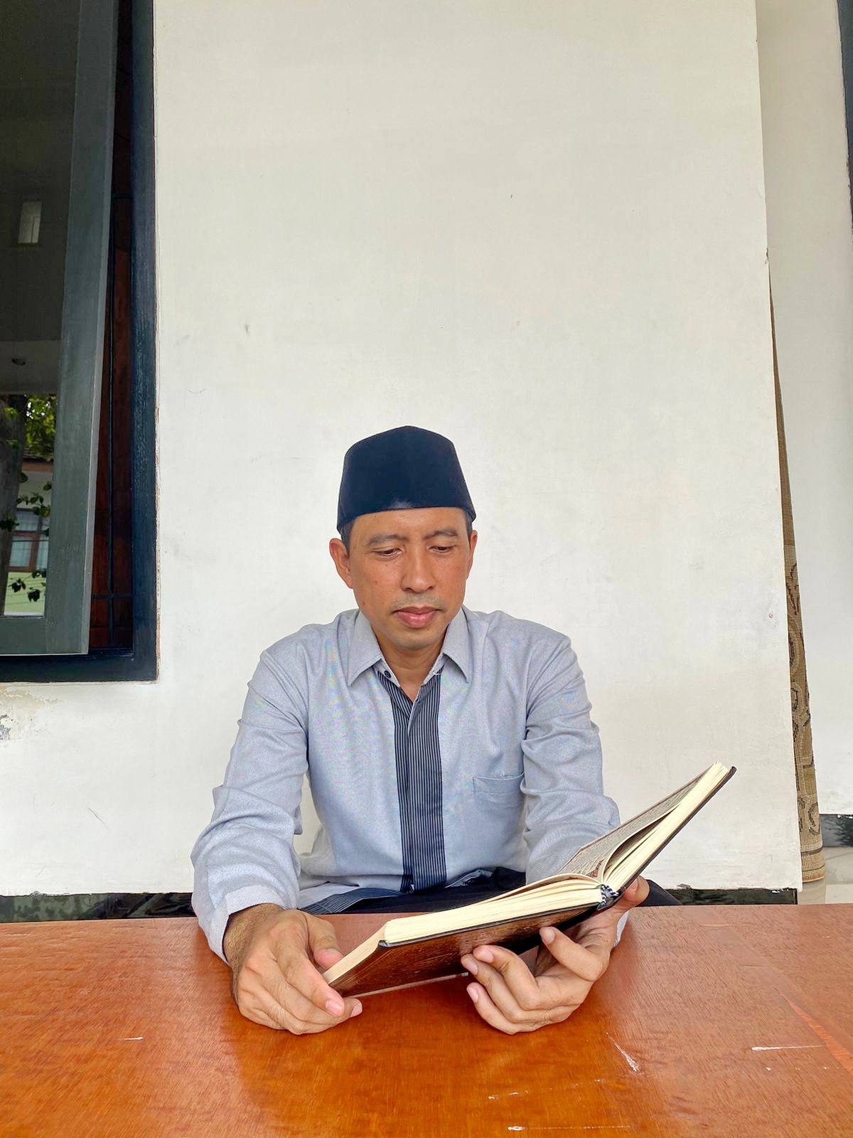IBADAH: Lora Ahmad Fauzi Sa&rsquo;dullah membaca Al-Qur&rsquo;an di kediamannya, Kelurahan Pangeranan, Bangkalan, Kamis (28/3). (AYU LATIFAH/JPRM)  &nbsp;