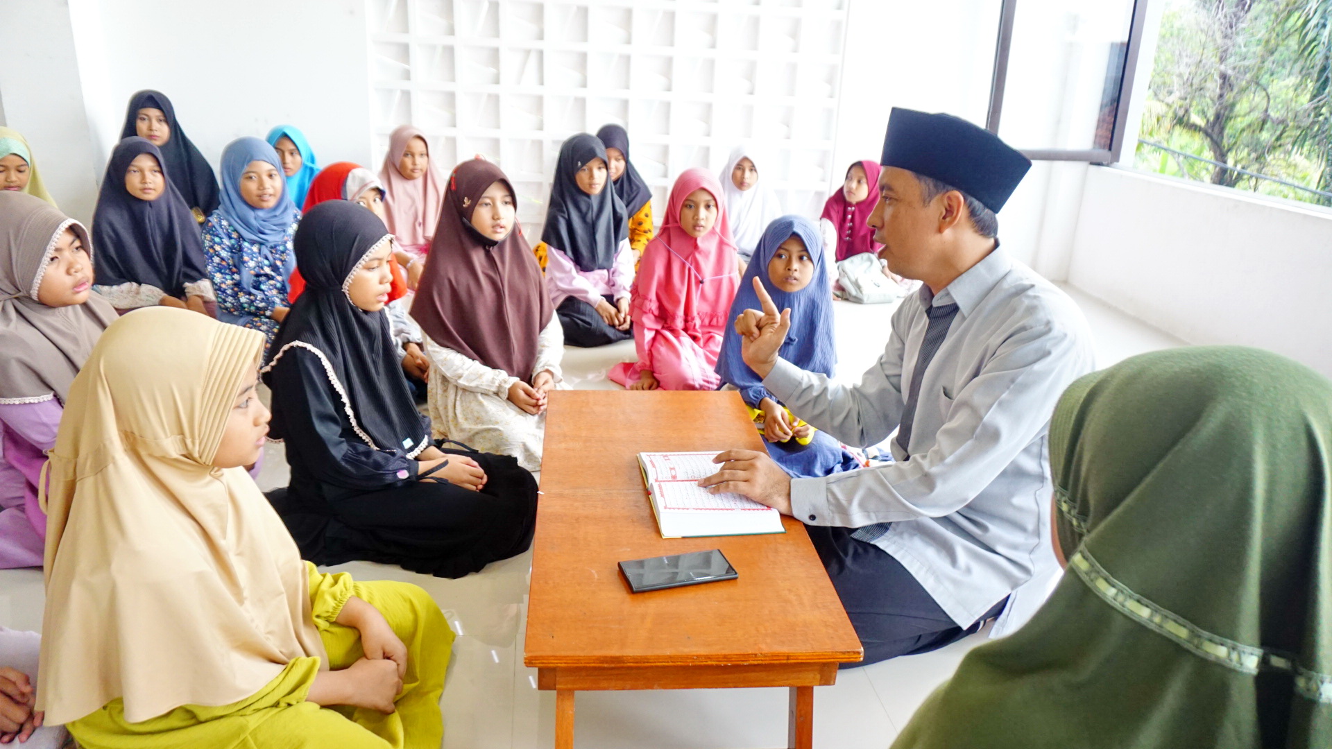 MENGAYOMI: Lora Ahmad Fauzi Sa&rsquo;dullah mengajari santri Al-Qur&rsquo;an di Gedung Qur&rsquo;an Center, Kelurahan Pangeranan, Bangkalan, beberapa waktu lalu. (VIVIN AGUSTIN HARTONO/JPRM)