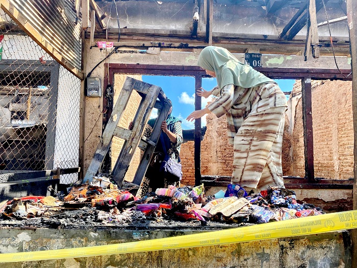 JADI ARANG: Pedagang memindahkan sisa barang yang tidak terbakar di Pasar Waru, Pamekasan, Sabtu (30/3). (MOH IQBAL AFGANI/JPRM)