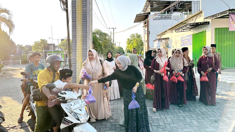 SEDEKAH: Firnanda Noeria R (baju hitam) membagikan takjil kepada warga di Jalan Kenanga, Kelurahan Mlajah, Sabtu (30/3). (FIRNANDA UNTUK JPRM)