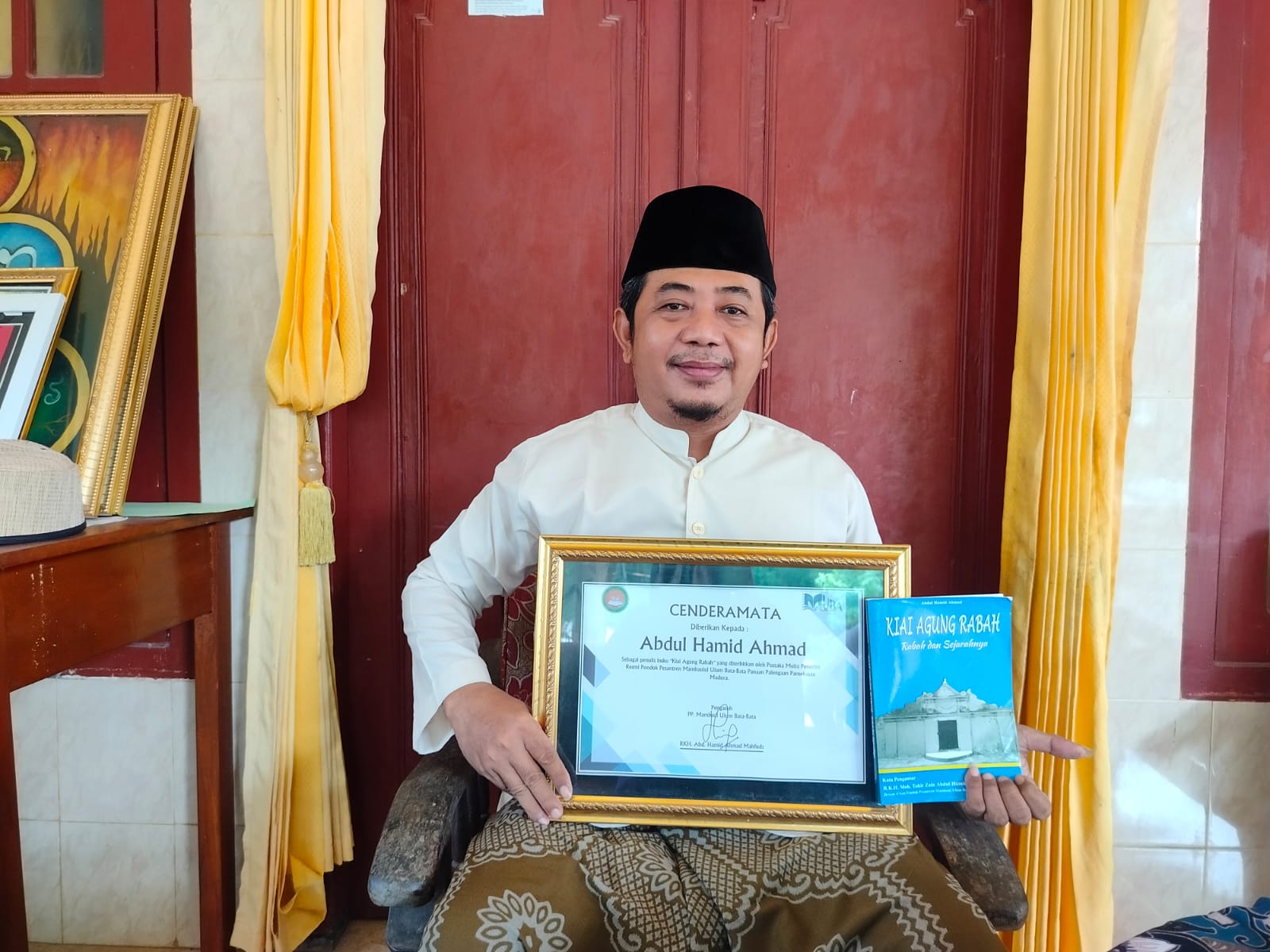 PRODUKTIF: K. Abdul Hamid Rabah memperlihatkan karya bukunya dan sertifikat penghargaan dari Ponpes Mambaul Ulum Bata-Bata, Minggu (31/3). (LAILIYATUN NURIYAH/JPRM)