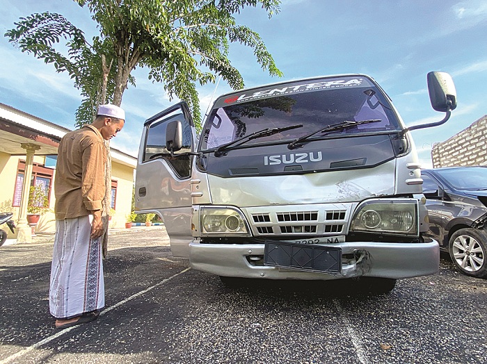 DIAMANKAN: Seorang warga melihat microbus yang terlibat kecelakaan di Satlantas Polres Pamekasan Rabu (3/4). (MOH. IQBAL AFGANI/JPRM)