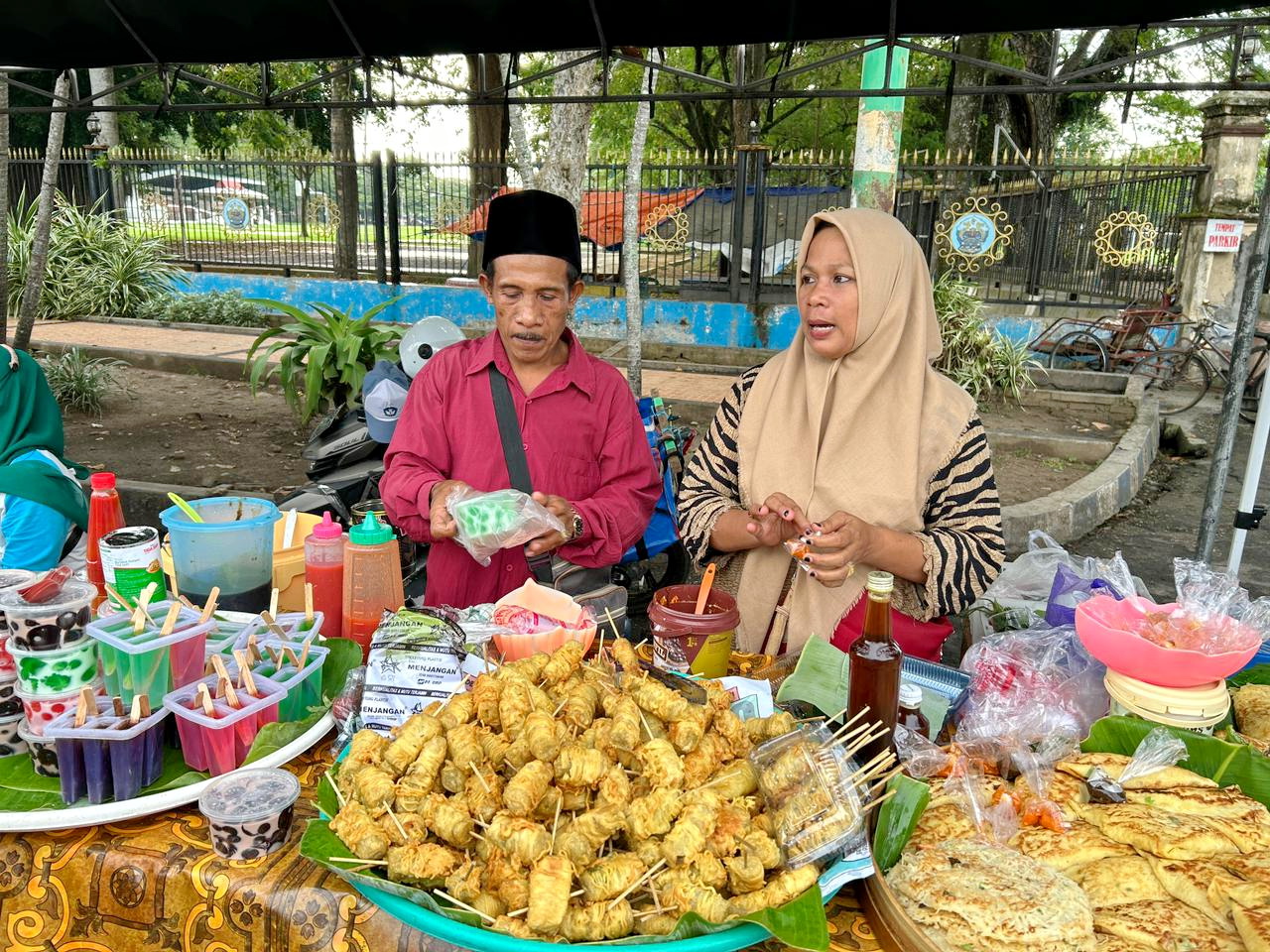 BANJIR PEMBELI: Riski dan Farida sibuk melayani pembeli martabak dan gorengan yang mereka jual di Bazar Takjil Ramadan, Jalan Letnan Abdullah, Bangkalan, Kamis (4/4). (VIVIN AGUSTIN HARTONO/JPRM)