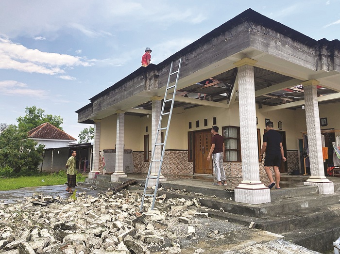 BERANTAKAN: Warga memperbaiki bangunan rusak akibat angin kencang di Desa Blumbungan, Kecamatan Larangan, Pamekasan, Rabu (21/2). (LAILIYATUN NURIYAH/JPRM)