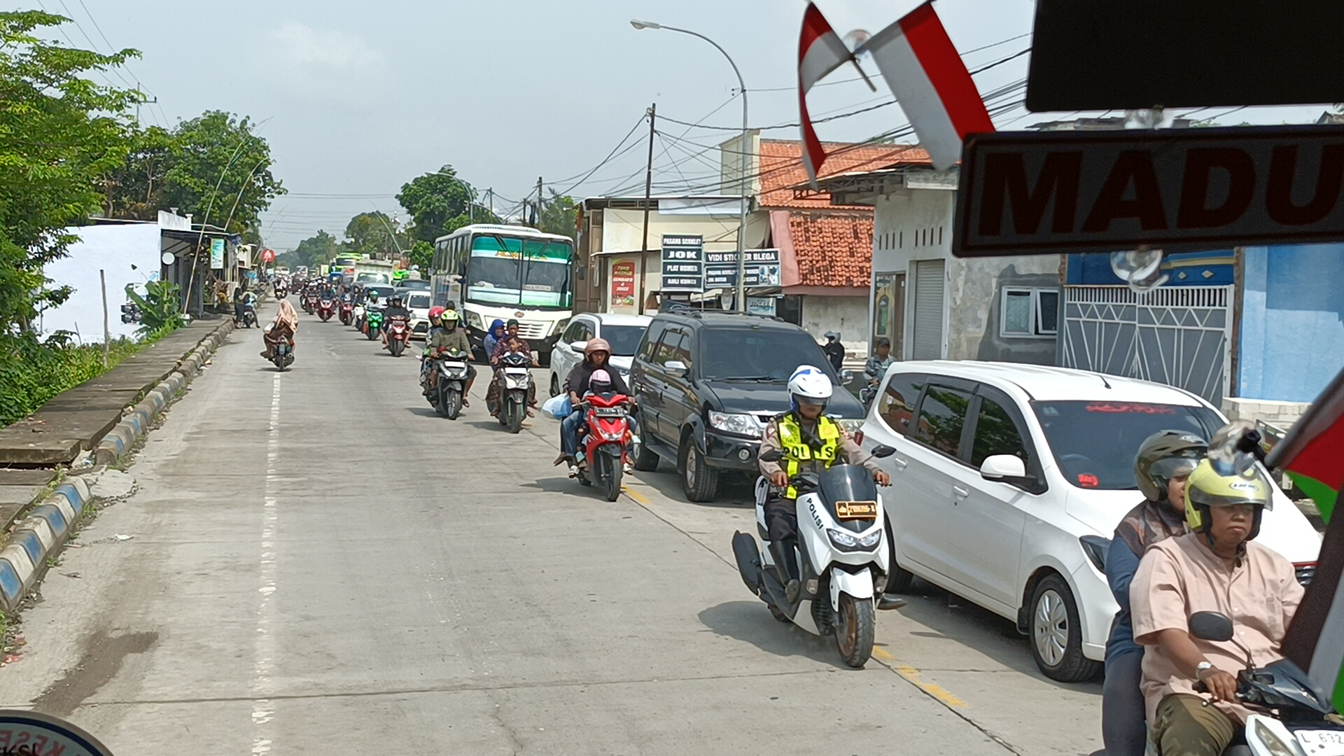 PULANG KAMPUNG: Para pemudik dari arah Surabaya mengular di Jalan Raya Blega, Bangkalan, kemarin. Polisi lalu-lalang mengatur lalu lintas. (LUKMAN HAKIM AG/JPRM)