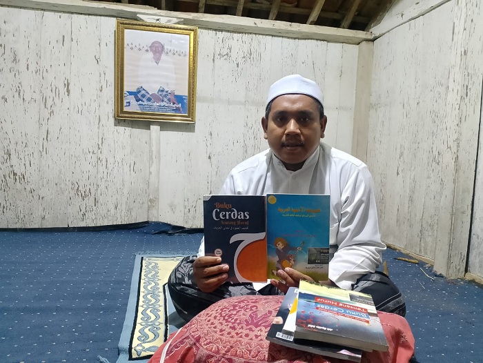 PRODUKTIF: Kiai Syahin Jalal menunjukkan buku pertamanya di kobungnya, Sabtu (6/4). (UBAIDILLAHIR RA&rsquo;IE/JPRM)
