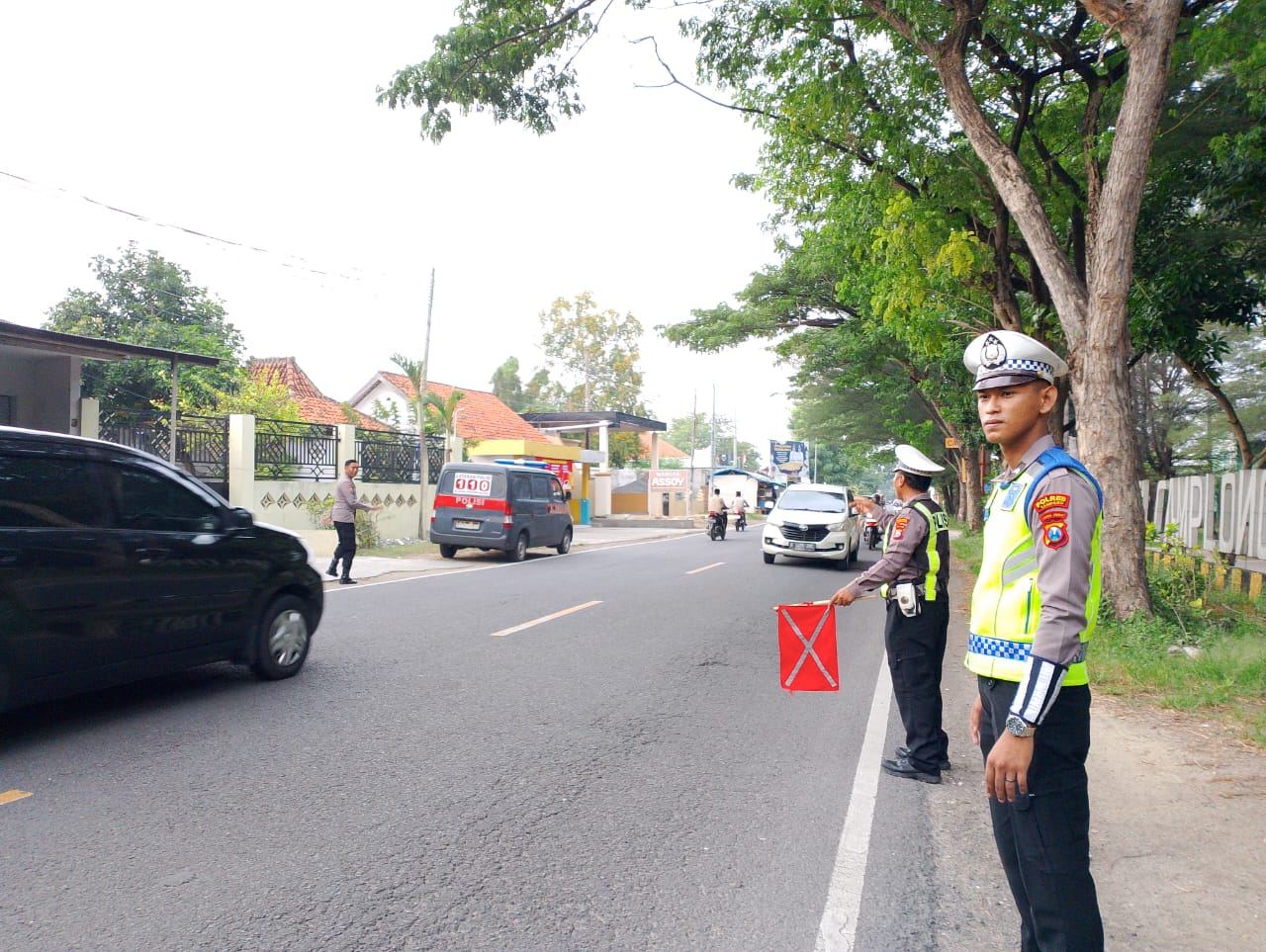 BERTUGAS: Personel Satlantas Polres Sampang sedang bertugas mengatur arus lalu lintas di Pos Pengamanan (Pospam) Kecamatan Camplong, Kabupaten Sampang pada Senin (8/4).