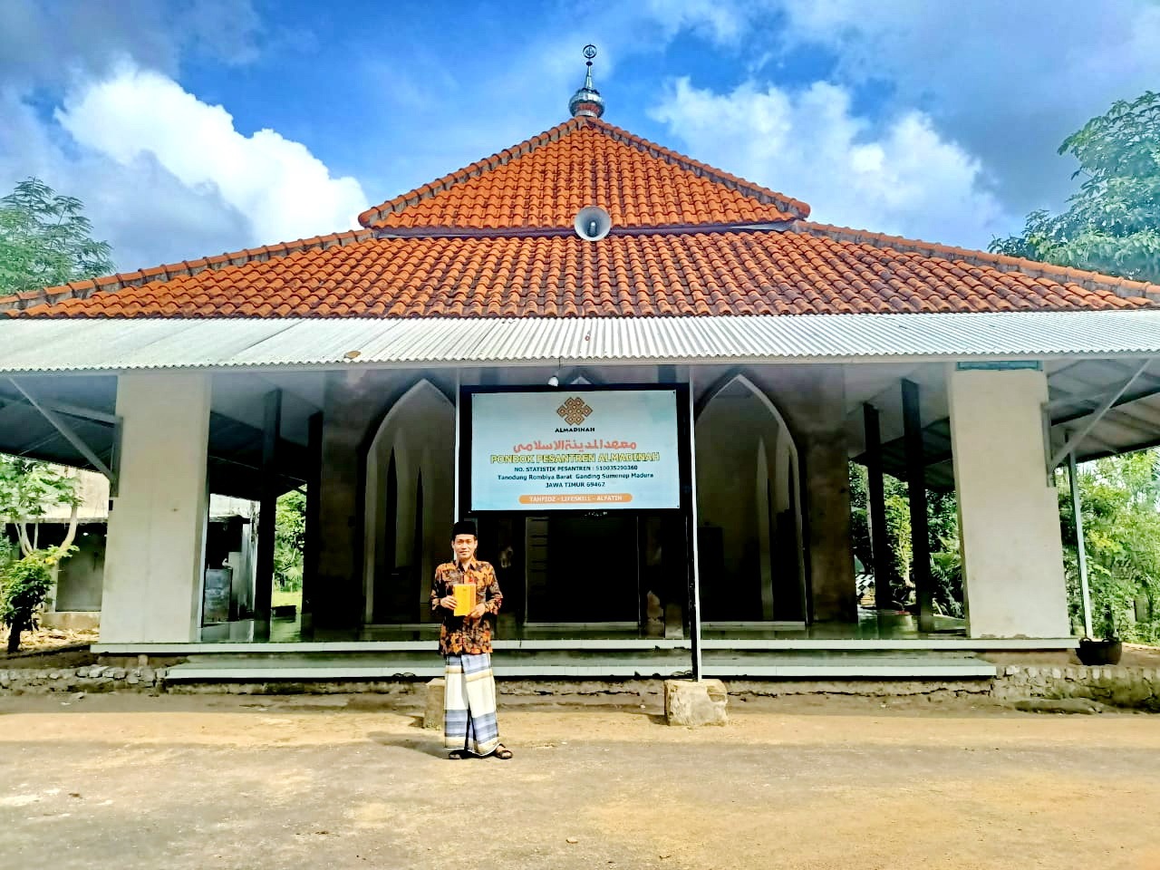 TEBAR MANFAAT: Kiai A. Mufti Khazin memegang buku konsep Alfatih di depan musala Ponpes Al Madinah, Desa Rombiya Barat, Kecamatan Ganding, Sumenep, Jumat (5/4).