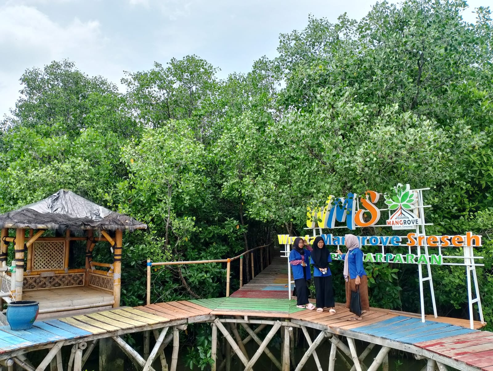 BERSANTAI: Petugas wisata menikmati spot foto di tengah mangrove WMS Marparan, Sreseh, Sampang, Sabtu (6/4). (UBAIDILLAHIR RAIE/JPRM)