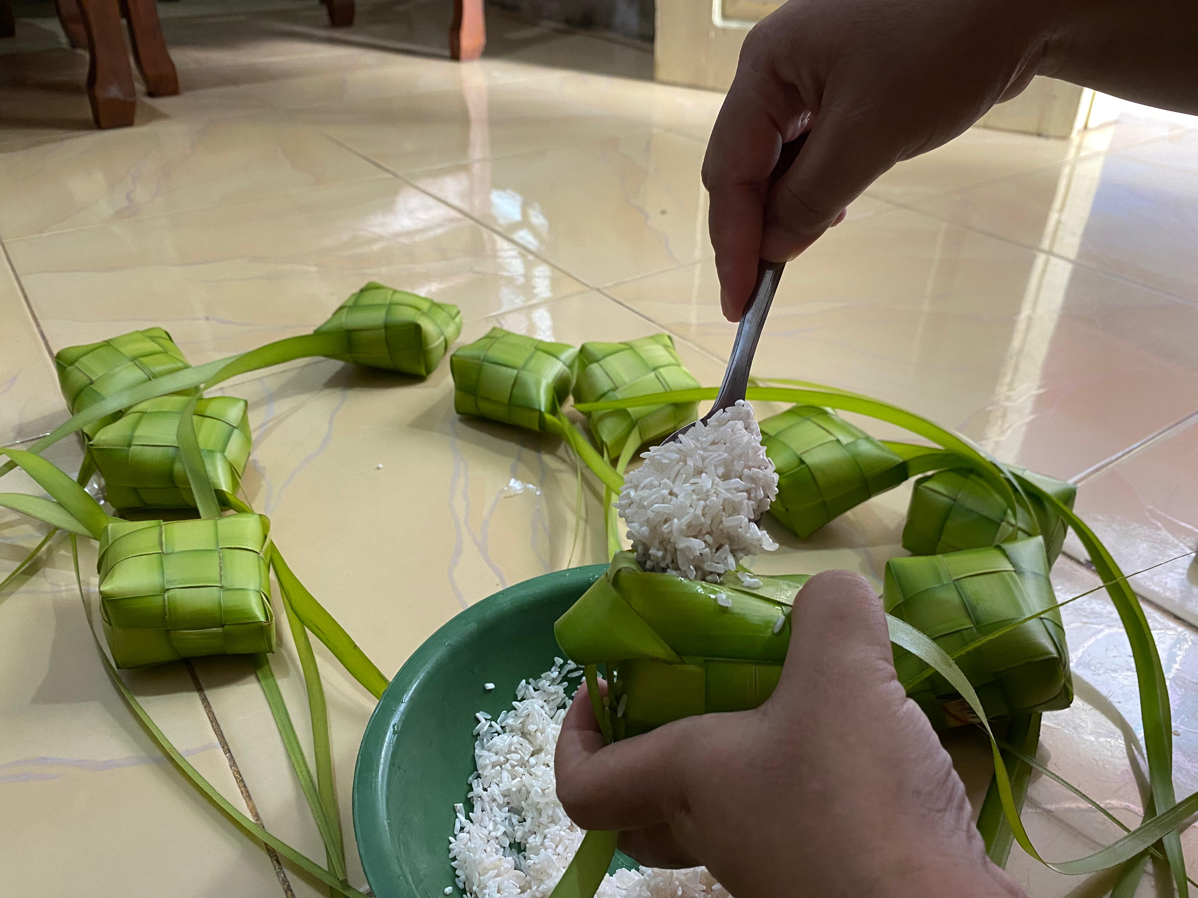 TRADISI: Proses pengisian beras ke dalam&nbsp;orong&nbsp;ketupat sebelum direbus.