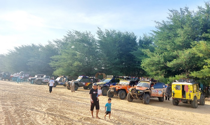 DIPADATI PENGUNJUNG: Pengunjung bermain di hamparan pasir Pantai Lon Malang, Desa Bira Tengah, Kecamatan Sokobanah, Sampang, Minggu (16/7/2023). (JUNAIDI PONDIYANTO/JPRM)