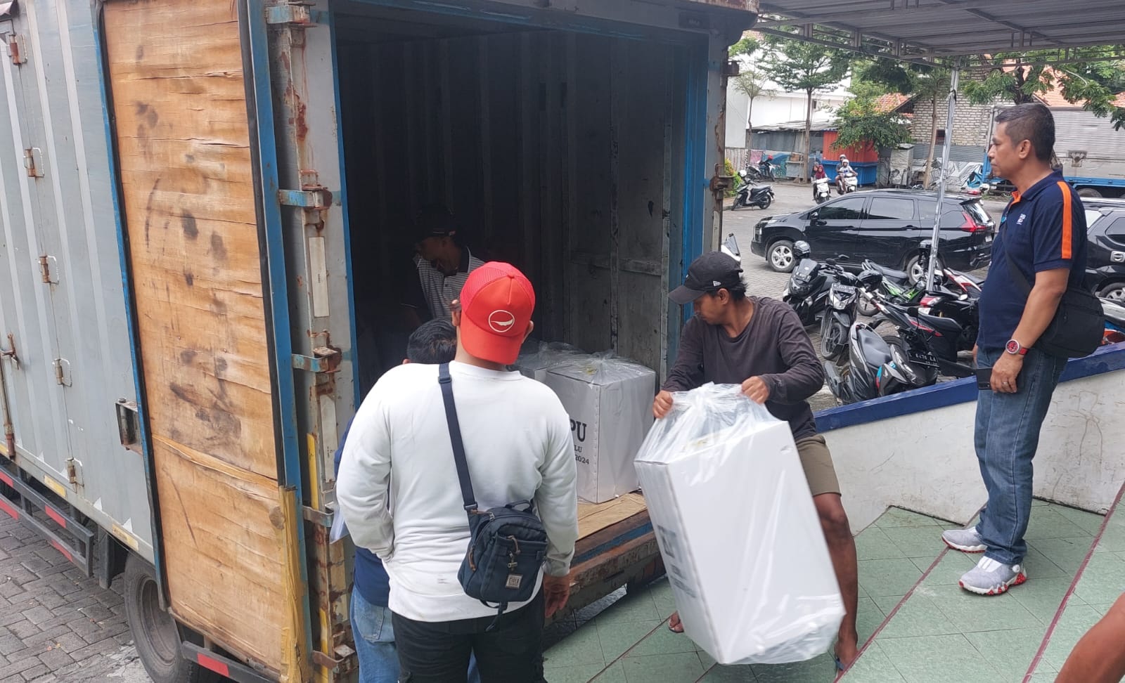 KPPS PILKADA: Petugas menaikkan logistik pemilu untuk diangkut ke wilayah kecamatan di gudang logistik GOR Indoor Sampang, Sabtu (10/2). (JUNAIDI PONDIYANTO/JPRM)