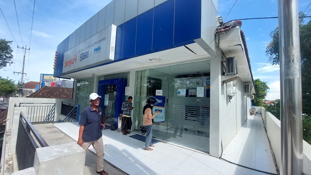 DIKELUHKAN: Warga berada di depan kantor BRI Unit Srimangunan, Jalan Panglima Sudirman, Kota Sampang, Selasa (23/4). (JUNAIDI PONDIYANTO/JPRM)