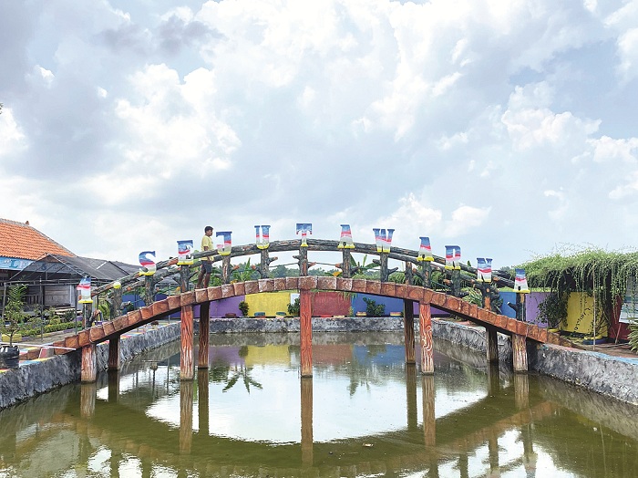 TERIK: Warga berjalan di atas jembatan Taman Edukasi Titik Sejuta Warna di Desa Pademawu Timur, Kecamatan Pademawu, Pamekasan, Minggu (7/4). (MOH. IQBAL AFGANI/JPRM)