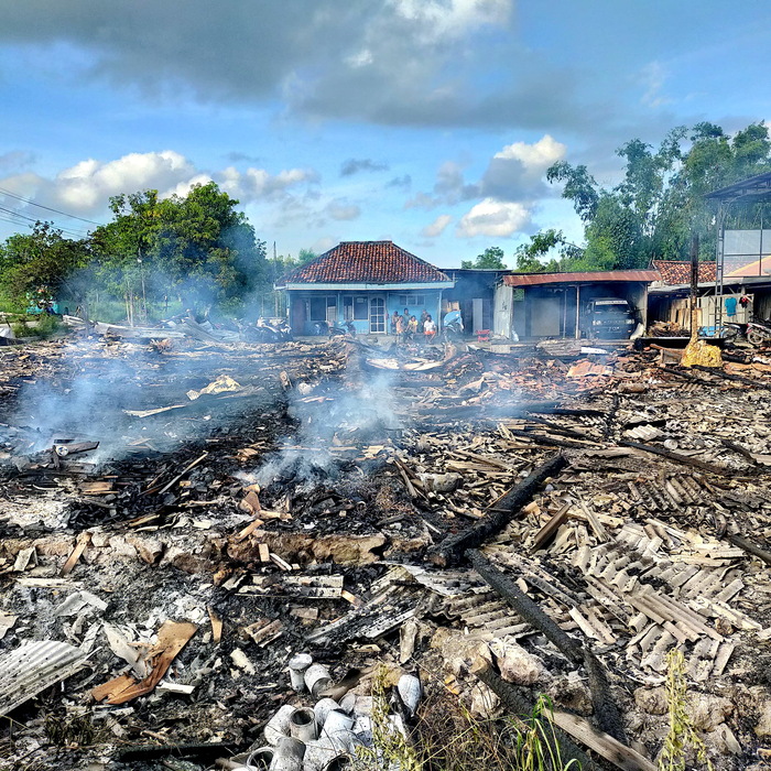 HANGUS: Asap keluar dari reruntuhan gudang dan rumah Munasib yang terbakar di Desa Bandaran, Kecamatan Tlanakan, Pamekasan, Jumat (28/4) malam. (ANIS BILLAH/JPRM)