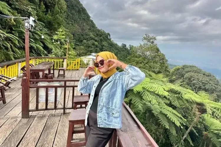 Seorang Perempuan Sedang Berpose di Salah Satu Cafe Kediri Pemandangan Gunung