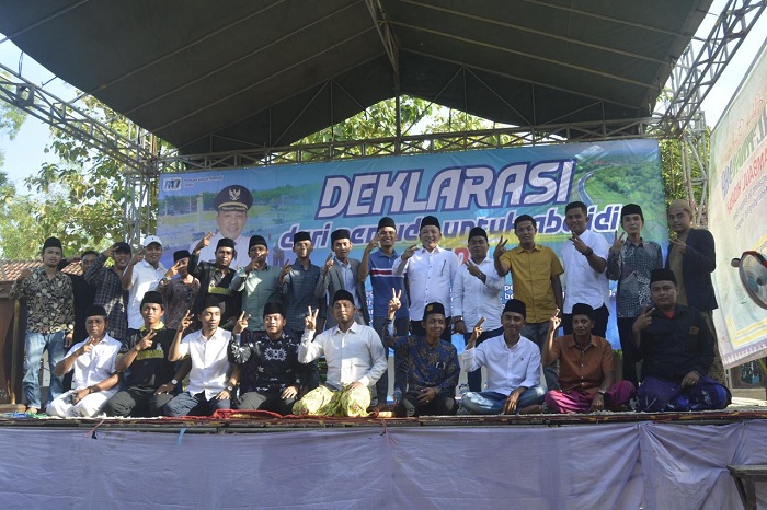 SATU TEKAD: Slamet Junaidi (berdiri, lima dari kanan) berfoto bersama pemuda dalam acara Deklarasi dari Pemuda untuk Aba Idi di Desa Batoporo Barat, Kecamatan Kedungdung, Sampang, Rabu (1/5).