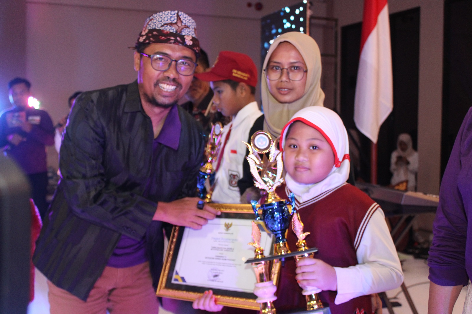BANGGA: Kadispendik Bangkalan Mohammad Yakub memberikan trofi kepada siswa MI Tiara Sahzi Salsabilla sebagai pemenang Pendidikan Awadrs kategori SD/MI, Sabtu (4/5) malam.
