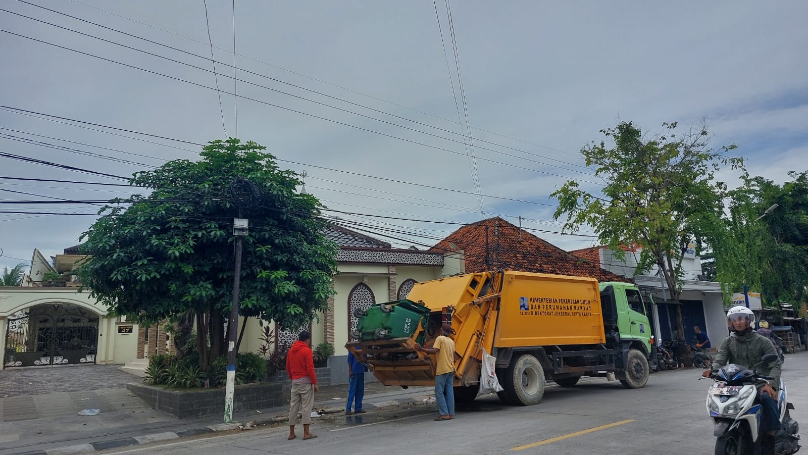 PEDULI LINGKUNGAN: Petugas kebersihan hendak mengangkut sampah menggunakan truk di Jalan Trunojoyo, Sampang, Sabtu (16/3). (JUNAIDI PONDIYANTO/JPRM)
