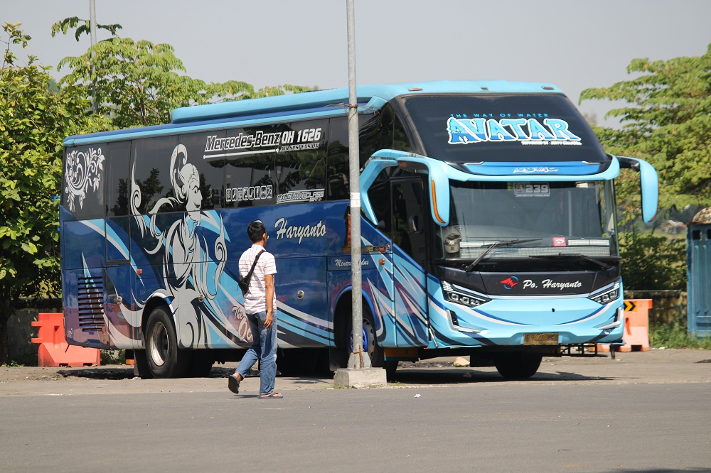 LENGANG: Warga berjalan di dekat bus yang tengah parkir di Terminal Bangkalan, Selasa (7/5). (VIVIN AGUSTIN HARTONO/JPRM)