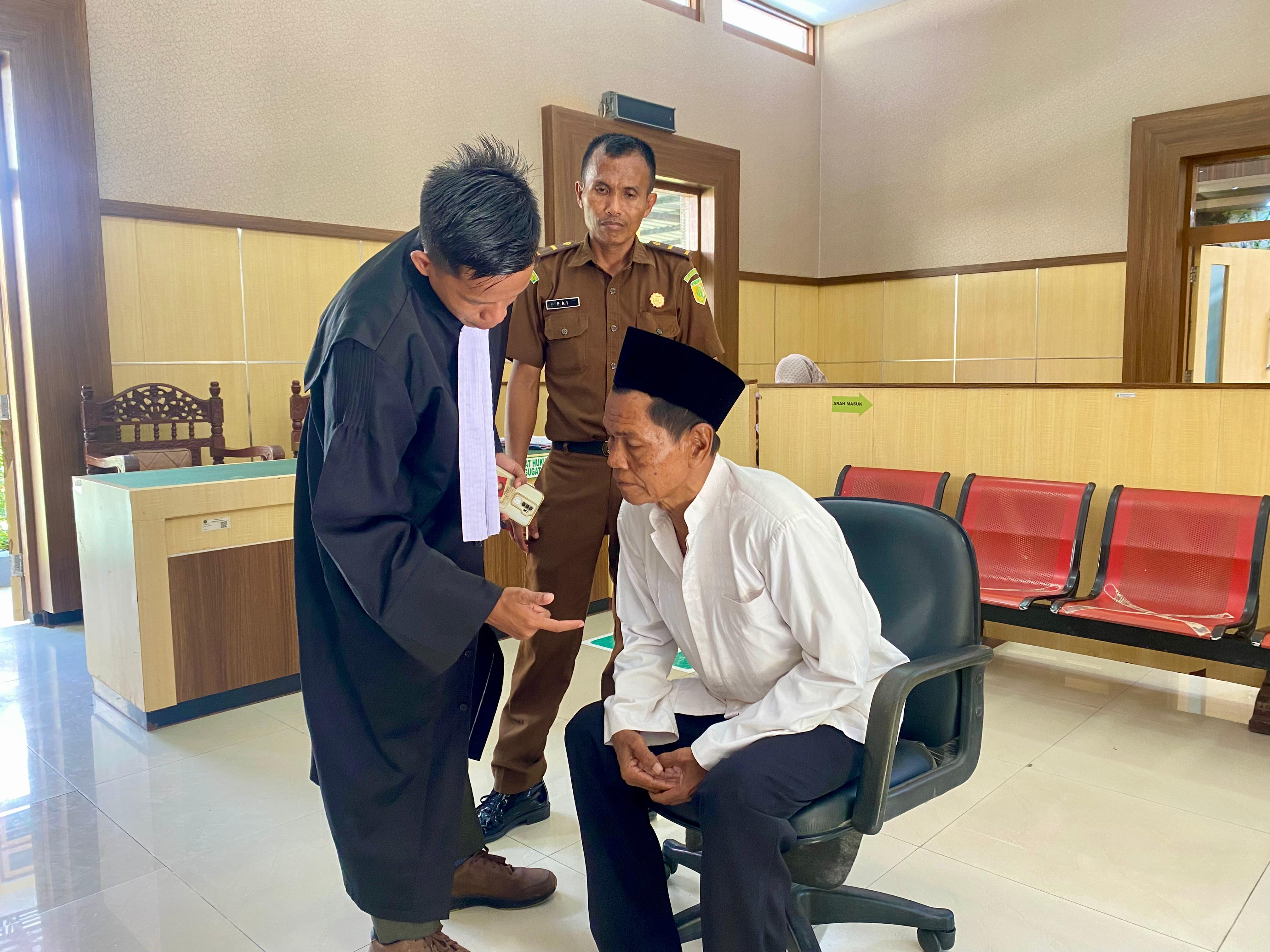 BERINTERAKSI: Margi berkomunikasi dengan penasihat hukumnya, Lukman Hakim, setelah mendengarkan vonis majelis hakim PN Pamekasan, Selasa. (MOH. IQBAL AFGANI/JPRM)