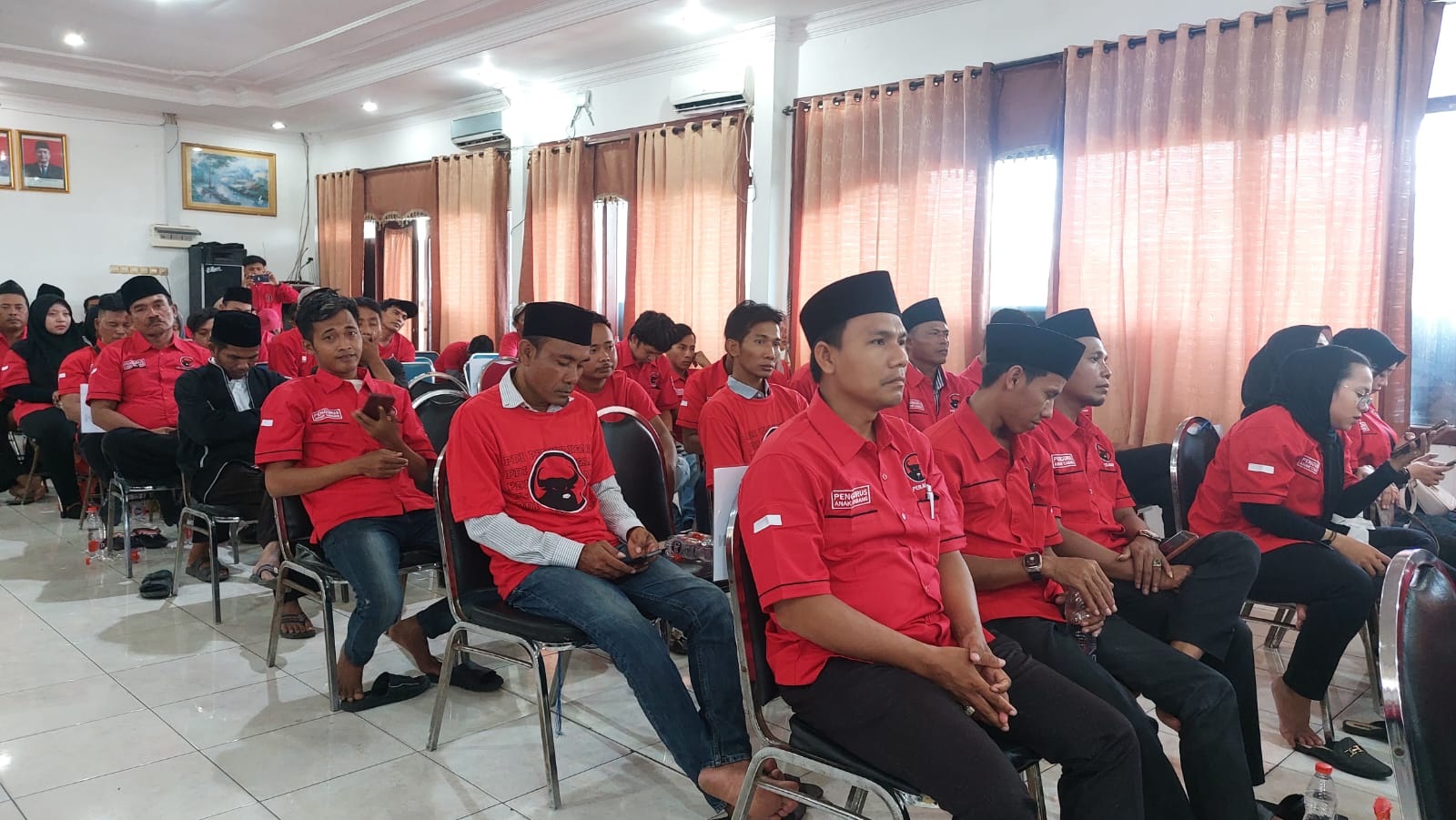 MERAH MENYALA: Sejumlah kader PDI Perjuangan Sampang saat mengikuti salah satu kegiatan partai politik di Gedung PKPRI Sampang, Sabtu (2/12/2023). (JUNAIDI PONDIYANTO/JPRM)