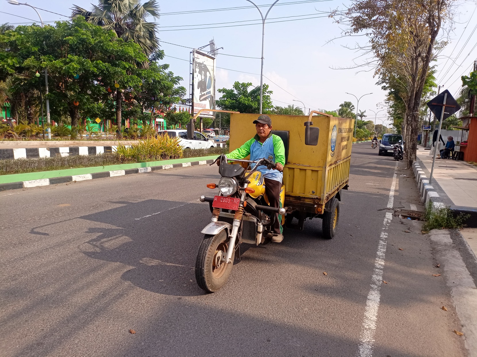 HONOR TAK LAYAK: Petugas kebersihan DLH Bangkalan mengendarai kendaraan roda tiga di Jalan Soekarno-Hatta Rabu (8/5).