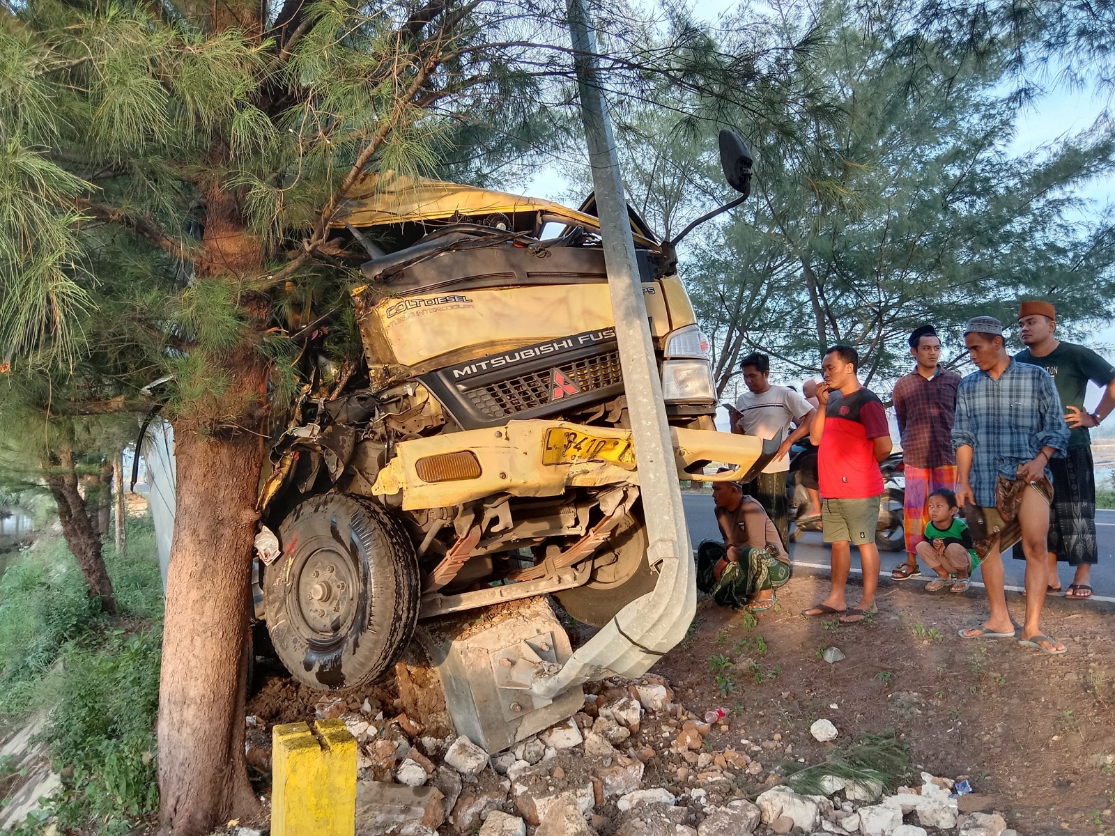 RUSAK PARAH: Warga melihat mobil boks yang terlibat laka tunggal di Jalan Raya Sumenep&ndash;Pamekasan, Desa Nambakor, Kecamatan Saronggi, Minggu (12/5). (MOH. IQBAL/JPRM)