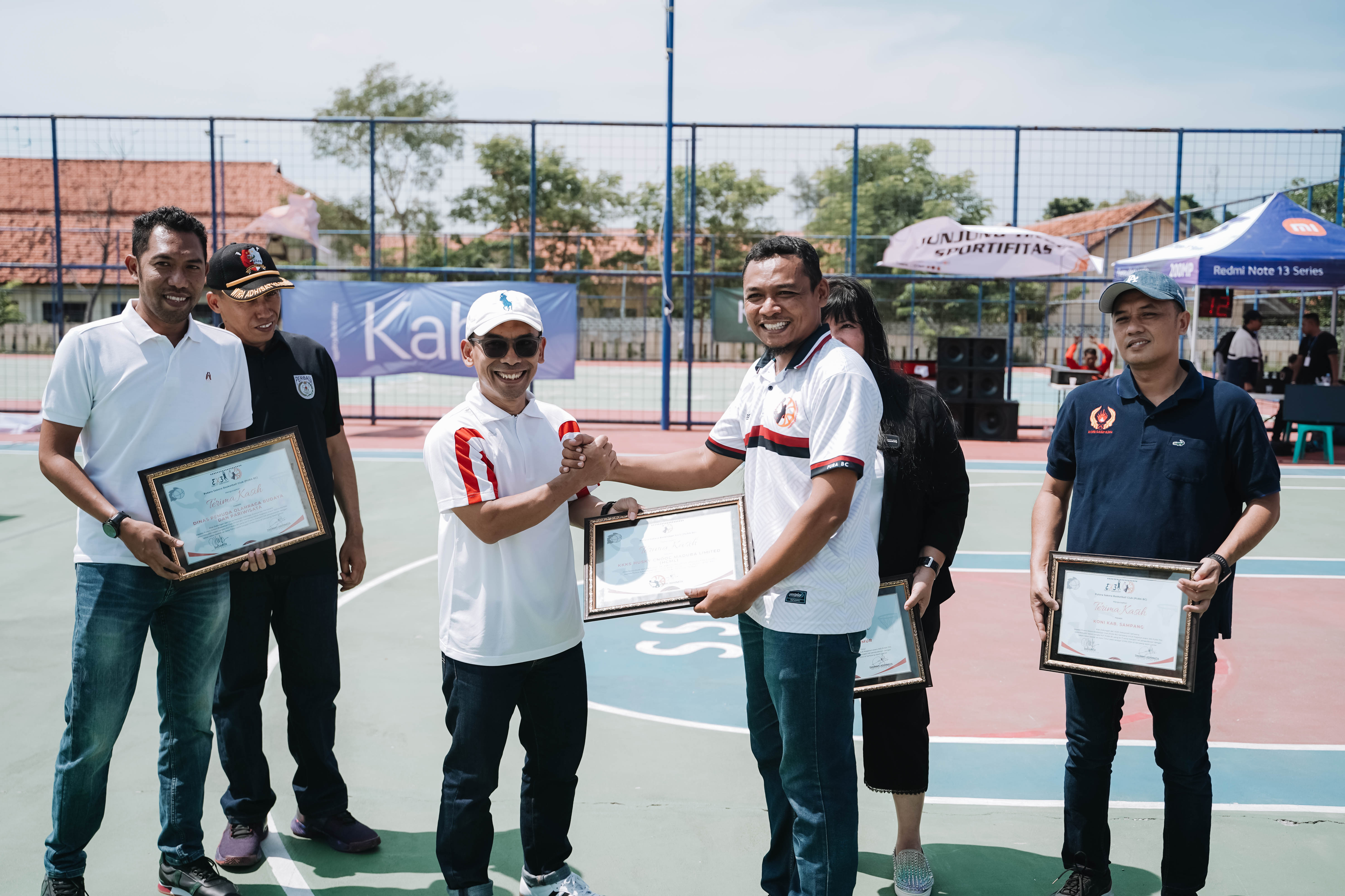 APRESIASI: Ketua Putra Sakera memberikan piagam kepada Head of Field Relations HCML Ali Aliyuddin usai pembukaan PURA 3x3 di SSC Sampang.