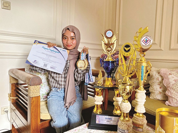 SEGUDANG PRESTASI: Fadya Izzaty Faiqotuzzihny menunjukkan sejumlah prestasi yang berhasil diraih di rumahnya di Kelurahan Demangan, Kecamatan/Kabupaten Bangkalan, Rabu (15/5). (AYU LATIFAH/JPRM)